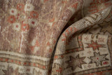 Distressed Oushak rug pile with visible knot heads and faded geometric floral patterns.