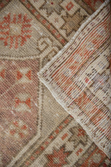Worn pile of vintage Oushak rug, faded brick red patterns, and visible hand-knotted foundation.