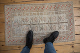 Distressed Oushak rug, soft beige, silver, pale raspberry tones, and worn low pile.