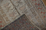 Distressed vintage Oushak rug corner showing worn pile, exposed foundation, and intact selvage.