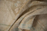 Distressed Oushak rug showing soft, textured pile in neutral sand and faded seafoam.