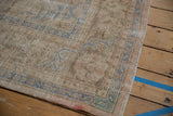 Distressed vintage Oushak rug side edge with intact selvage and faded blue border patterns.