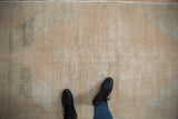 Distressed vintage Oushak rug showing worn knot heads, visible foundation, and soft cream, beige, green tones.