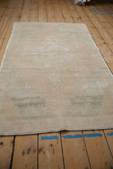 Worn pile texture of distressed vintage Oushak rug, showing visible foundation and seafoam green accents.