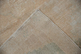 Distressed Oushak rug corner, worn pile, exposed foundation, intact side selvage.