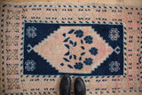 Distressed pink field and cobalt blue stepped medallion with tree of life design.