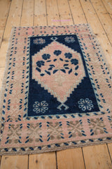 Distressed pink and cobalt blue Oushak rug with stepped medallion contour and worn pile.