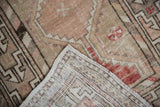 Vintage Oushak runner's distressed beige pile, with hand-knotted foundation and intact selvage.