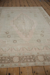 Distressed vintage Oushak rug border and field with pale seafoam green, ivory, and dusty rose tones.