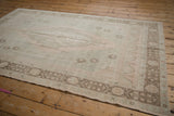 Distressed vintage Oushak rug's dusty bronze border with geometric motifs and intact selvage.