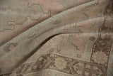 Soft pile and stepped motifs in pale seafoam green and dusty rose on the Oushak rug.
