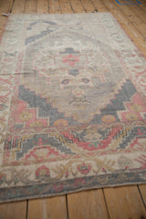 Distressed Oushak rug featuring abrashed field with faded raspberry and denim blue patterns.
