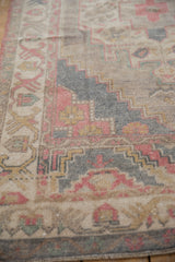 Textured distressed pile with stepped spandrel on a vintage Oushak rug in faded tones.