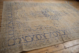 Worn beige pile texture and faded cobalt blue patterns on a distressed Oushak rug.