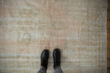 Detailed texture of a distressed Oushak rug showing mostly even wear in pale pink and seafoam green.