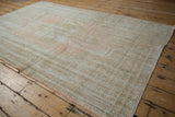 An angled perspective on the time-softened pile and textural wear of a distressed Oushak rug.