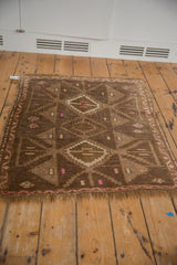Distressed Kars square rug displaying abrashed brown pile with geometric pink and ivory flowers.