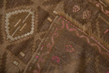 Distressed chocolate brown Kars rug with pink geometric vine and worn pile.
