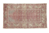 Vintage distressed Oushak rug in faded purple with geometric floral borders in mint green and pale turquoise.