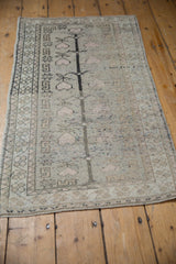 Distressed Oushak rug corner, charcoal tree of life, pale dusty rose, geometric border.
