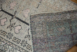 Distressed Oushak rug showing worn beige pile, pale rose patterns, and hand-knotted reverse foundation.
