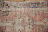 Mostly even wear across knot heads and the original selvage of a distressed Oushak rug.