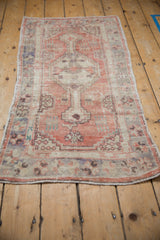 Angled perspective of a vintage Oushak runner showing its stepped medallion and distressed blush colors.