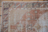 Worn corner spandrel and intact side selvage on a distressed vintage Oushak rug runner.