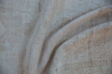 Textured distressed pile and foundation in muted ivory and beige of a vintage Oushak runner.