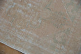Distressed vintage Oushak rug runner close-up, showing low pile, knot heads, and white fringe.