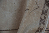 Textured pile of vintage distressed Oushak rug with chocolate brown geometric border.