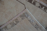 Vintage distressed Oushak rug showing hand-knotted reverse, secured edge, and pile texture.