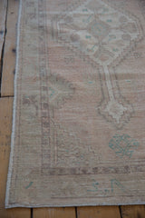 Distressed Oushak runner texture, revealing faint foundation, knot heads, and pale rose floral motifs.