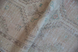 Distressed vintage Turkish Oushak runner's ivory pile, pale rose and turquoise geometric patterns, with visible wear.