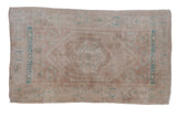 Vintage distressed Oushak rug with dusty mauve field, center medallion, turquoise starbursts.