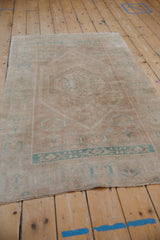 Distressed vintage Oushak rug texture, revealing faded ocean turquoise stylized patterns.
