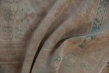 Textured, low pile of a distressed Oushak rug showing soft, muted turquoise designs.