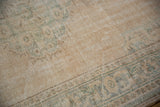Distressed vintage Oushak rug close-up showing worn cream, beige, and seafoam green pile.
