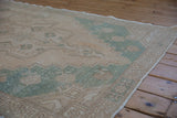 Evenly worn pile and geometric border of a distressed Turkish Oushak rug runner.