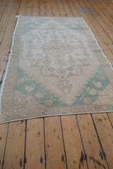 Full length perspective of a distressed Oushak runner in pale turquoise and sand tones.