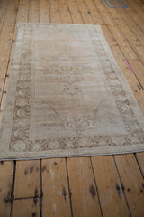 Muted ivory and coffee brown border detail on a distressed vintage Oushak runner corner.