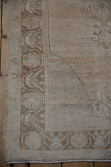 Distressed texture and stylized border pattern of the vintage Oushak runner in cream and coffee.