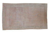 Distressed vintage Oushak rug featuring faded ivory, mauve, green floral pattern.