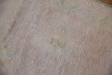 Distressed Oushak rug pile showing even wear, with subtle beige, seafoam, and mauve hues.