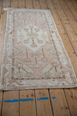 Distressed Oushak runner's textured pile with expressive serrated contour in soft ivory, melon.