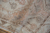 Folded distressed Oushak runner pile, revealing worn ivory, dusty melon, and coffee brown patterns.