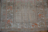 Distressed texture of a vintage Oushak rug's stylized floral border in tangerine and oxidized silver.