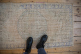 Overhead view of a distressed Oushak rug's soft, time-worn pile and texture underfoot.