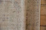 Visible knot heads and textured low pile of a distressed hand-knotted vintage Oushak rug.