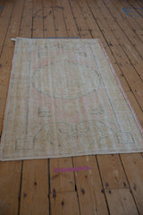 Distressed Oushak rug's texture with visible wear to knot heads and foundation.